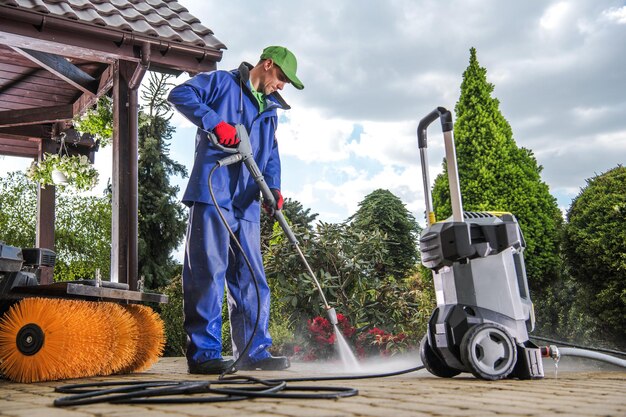 Home exterior being refreshed with a pressure washer, fresh paint, and updated landscaping for improved curb appeal.