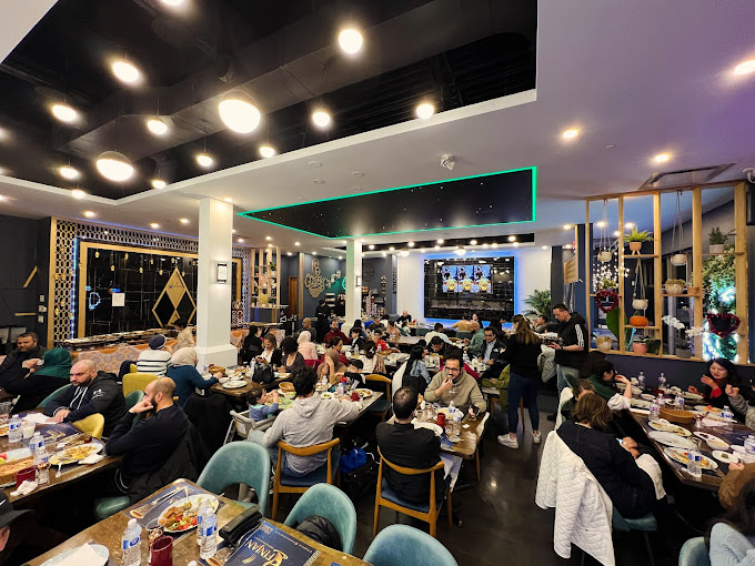 Busy restaurant with people dining and socializing in a modern interior.