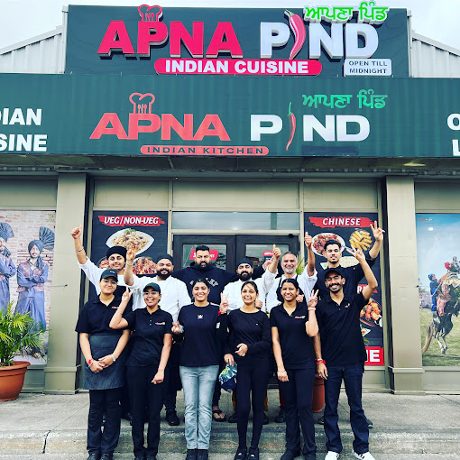 Apna Pind restaurant team posing happily in front of their restaurant in Mississauga